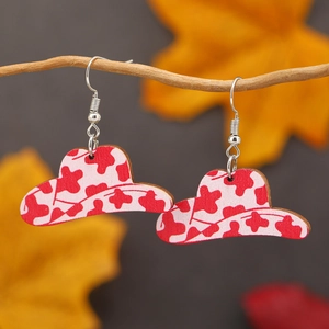 Boucles d'oreilles chapeau de cowboy avec motif vache suspendues sur des branches