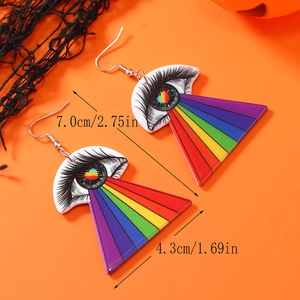 Détail de boucles d'oreilles œil d'Halloween avec rayons arc-en-ciel sur fond orange