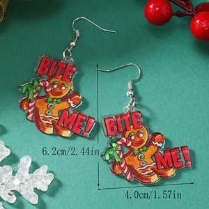 Dettaglio degli orecchini in acrilico omino di pan di zenzero con testo Bite Me e decori