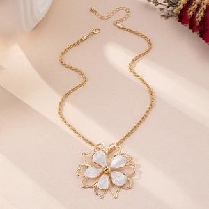 Detail of flower pendant necklace with gold twisted chain and white enamel petals