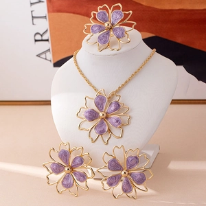 Detail view of purple floral jewelry set with golden edges including necklace and ring