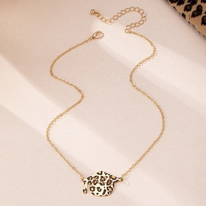 Golden 2025 graduation cap pendant necklace with leopard print on beige background