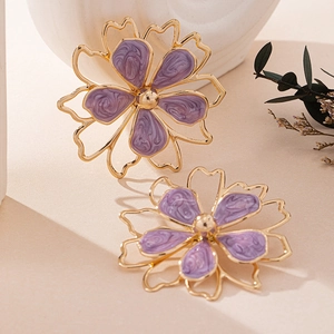 Detail of double-layer gold flower earrings with purple marbled enamel and golden beads