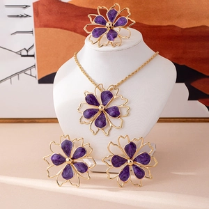 Detail view of purple floral jewelry set featuring marble textures and golden metal edges