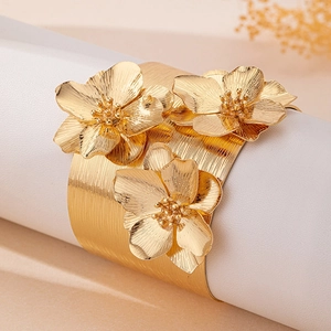 Bracelet manchette en métal doré brossé avec trois fleurs sculptées en relief élégantes