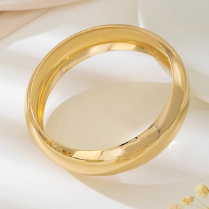 Bracciale rigido aperto largo dorato con finitura a specchio lucida e design ad arco