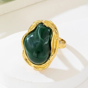 Close-up of vintage baroque style ring with large irregular green gemstone and gold border