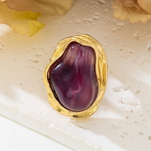 Macro detail of French vintage ring featuring purple baroque stone and gold pleated metal