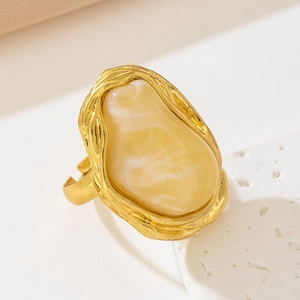 Macro detail of French vintage baroque ring with irregular amber-tone stone and gold texture