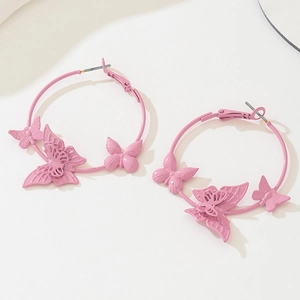 Pink matte butterfly hoop earrings with three butterfly charms on cream background