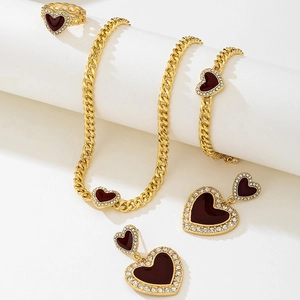 Macro view of vintage gold Cuban chain set with red enamel heart and white rhinestones