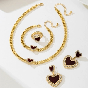 Detailed view of golden heart jewelry set with burgundy enamel and sparkling crystals