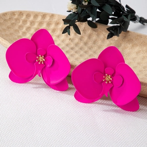 Detailed macro view of orchid earrings in magenta matte finish with gold center beads