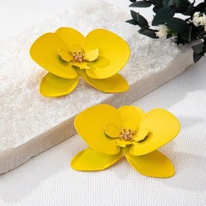 Detailed shot of yellow orchid floral earrings with crystals on stone background