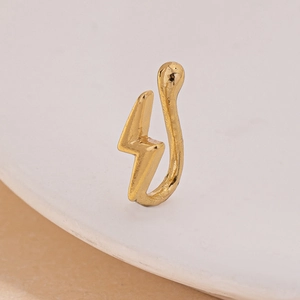 Dettaglio macro di un finto anello da naso a fulmine dorato con finitura lucida