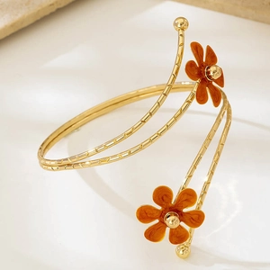 Bracciale da braccio a spirale dorato con fiori in smalto arancione su pietra beige