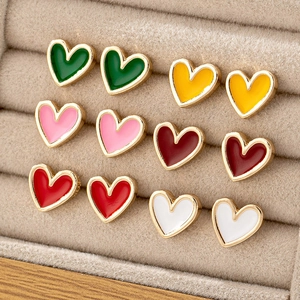 Macro shot of heart-shaped stud earring set in six colors on beige velvet tray