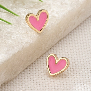 Detailed close-up of pink heart-shaped earrings with gold trim on marble backdrop