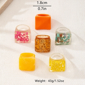 Detail view of colorful geometric resin rings with gold foil and stone inlays for women