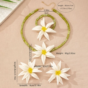 Vierteiliges Schmuckset mit weißen Lilienblüten und grünen Perlenketten im Detail
