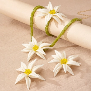 Blumiges Schmuckset mit weißer Lilienhalskette und grünen Perlenakzenten für den Sommer