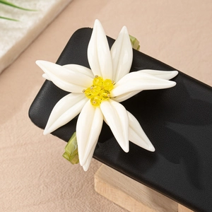 Makroaufnahme eines Blumenrings mit weißen Blüten und grünem Harz-Geometrieband