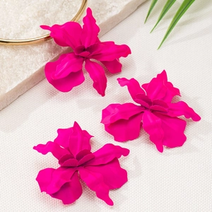 Vue détaillée des boucles d'oreilles fleurs rose vif avec finition mate et textures