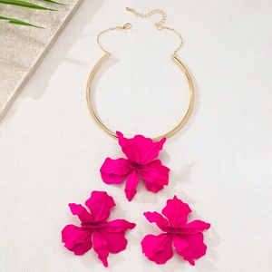 Détail de l'ensemble collier et boucles d'oreilles fleur 3D fuchsia avec finition dorée