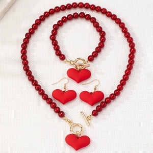 Detail of red beaded jewelry set with gold OT clasp and matte heart pendants