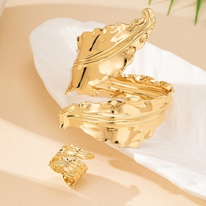 Golden chunky geometric jewelry set with a wide textured cuff bracelet and open ring