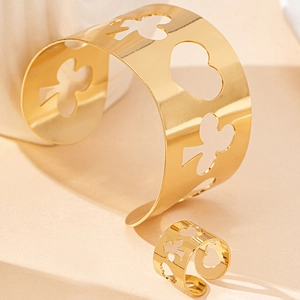 Golden hollow heart and clover jewelry set featuring wide open bangle and matching ring