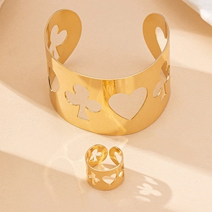 Detail view of gold metal jewelry set with hollowed heart and poker suit patterns