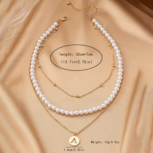 Elegant triple-layer necklace set with pearls, golden bead chain, and letter A pendant