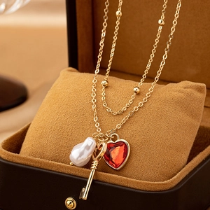 Collar vintage con colgantes de corazón y llave y perla barroca en cadena de oro