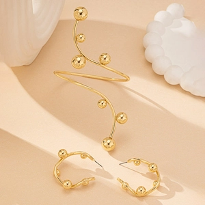 Set di orecchini a C dorati e bracciale a spirale con sfere di metallo lucido