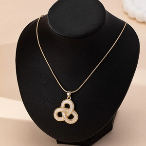 Dettaglio della collana a catena serpente dorata con ciondolo geometrico triquetra bianco