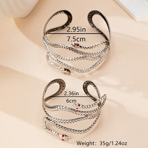 Détails des bracelets serpent en argent avec yeux en strass rouges et textures d'écailles