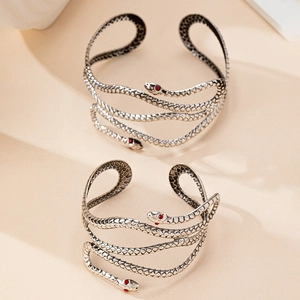Gros plan sur un bracelet serpent en argent vieilli avec écailles et yeux rouges