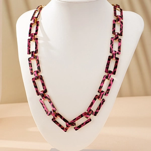 Détail des gros maillons imprimé léopard sur un long collier élégant pour femme
