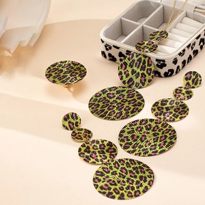 Dettaglio del set di gioielli con stampa leopardata geometrica e dischi verde neon e rosa