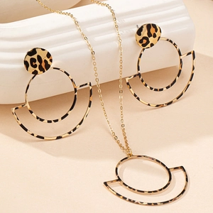 Macro detail of leopard print pendant necklace and earrings set with gold hollow circles