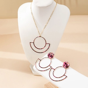 Detail view of pink leopard print geometric circle pendant necklace and earrings set