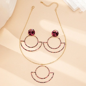 Detail of pink leopard print jewelry set with round geometric gold metal frames