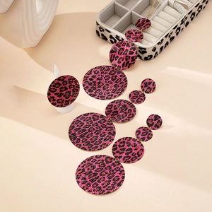 Dettaglio macro di set gioielli boho con stampa leopardata rosa e perline