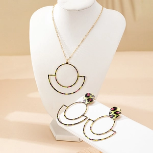 Detail view of gold geometric circle necklace and leopard print earrings jewelry set