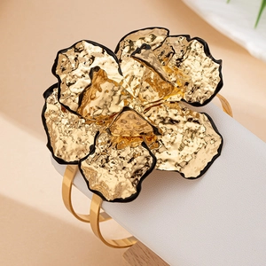 Bracciale rigido a camelia dorata con trama martellata e bordi dipinti di nero