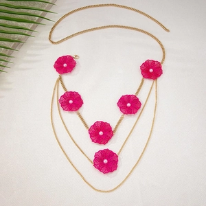 Detail of gold layered chain belt featuring hollow rose red flowers and white pearls