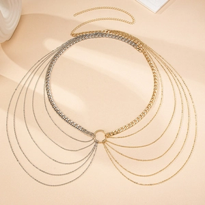 Détail d'une ceinture chaîne multicouche or et argent avec des franges élégantes fluides