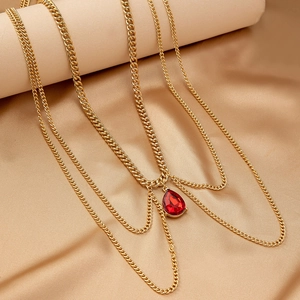 Elegant multi-layered gold body chain featuring a vibrant red pear-cut gemstone pendant