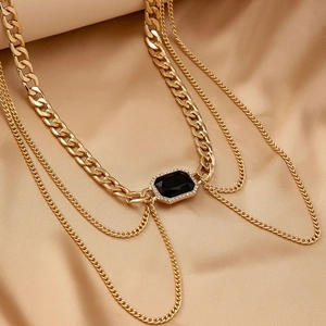 Elegant multilayer gold chain belt featuring a rectangle black gemstone on satin background